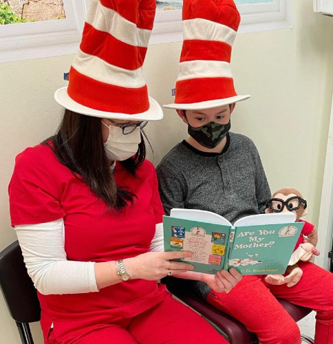 a woman reading a dr. seuss book to a boy