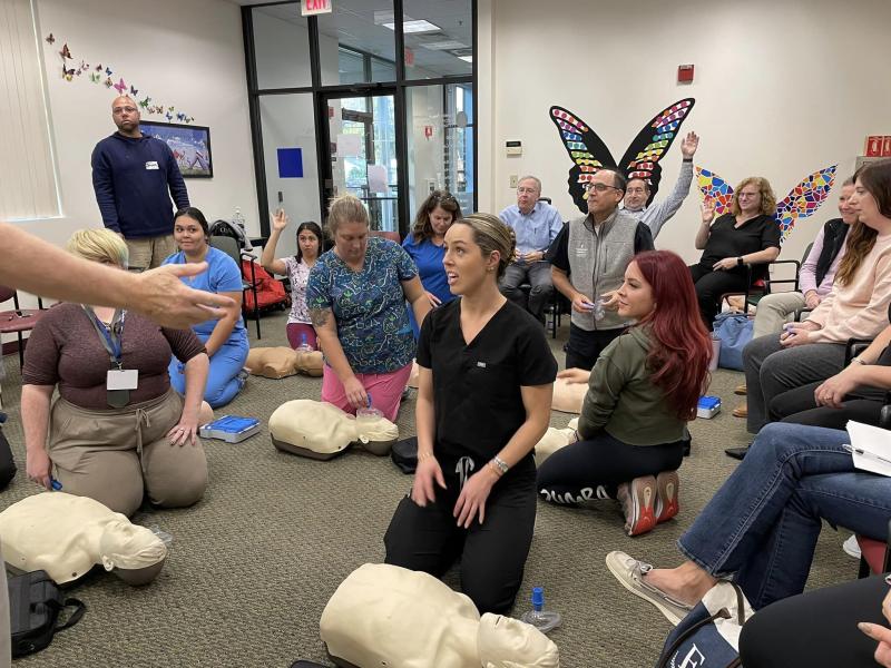 a group of medical professionals on the floor with CPR Annies