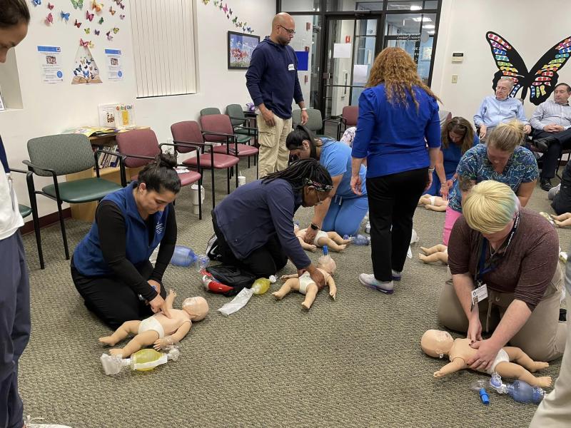 a group of medical professionals practicing CPR on infant Annies